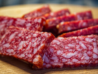 A close-up of sliced salami, showcasing the marbled fat and lean meat, ideal for culinary themes.