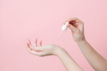 Pipette of serum or essential oil on gentle background. Presenting luxury skincare products