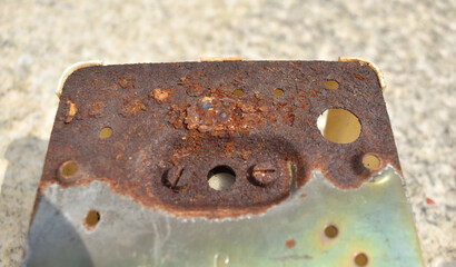 A closeup picture of a rusted Iron plate with a tin coating. Oxidation of metal is called rusting