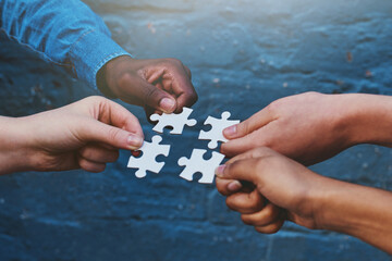 Teamwork, business and hands of people with puzzle for unity or collaboration with joint effort for project. Group, diversity and pieces together for planning or partnership, union and engagement.