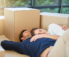 Couple, sleeping and moving in new home with box on floor for property, apartment or building. Tired man and woman asleep in relaxation for house investment, rest or break with boxes in living room