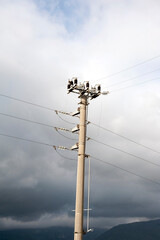 Obraz premium Overheard power line post along a road in the countryside.