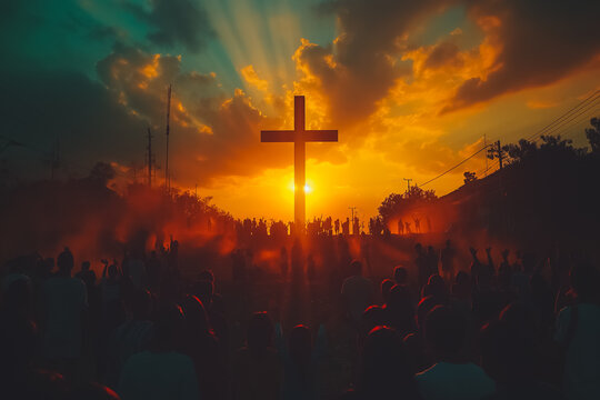 A large crowd of people are gathered around a cross, with the sun shining on it