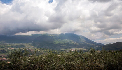 Cloudy sky over Olive tree grove with valley and Taburno-Camposauro mountain massif in the...
