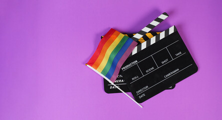 Two Clapper board and rainbow pride flag on purple or violet background.