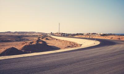 Desert asphalt road, travel concept, color toning applied, Egypt.