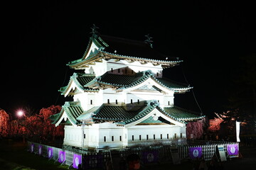 Fototapeta premium Hirosaki Castle surrounded by Pink Sakura or Cherry Blossom at Night in Aomori, Japan - 日本 青森 弘前城 桜の花 夜景