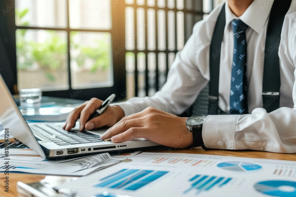 Poster close-up of a businessman working on laptop with charts and data analysis in office