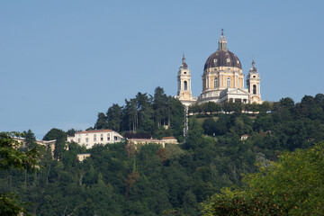 TURIN, ITALY - SEP 14, 2019: Superga, actually Basilica della Nativita di Maria Vergine, an important pilgrimage church near Turin in Italy, photographed from a distance with trees