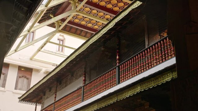 Rain gently falls on ancient Sri Dalada Maligawa Temple, Kandy. Sacred site with elegant wood carvings, golden roof details, history vibe. Indoor view, echoes. Traditional architecture, in Sri Lanka.