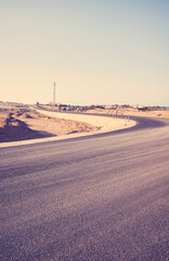Desert asphalt road, travel concept, front focus on asphalt, color toning applied, Egypt.