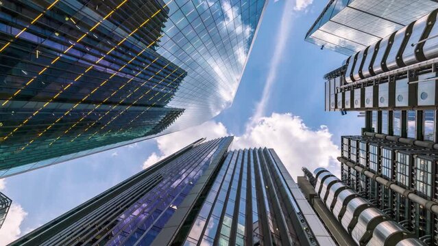 Time lapse view of looking directly up at the skyline of the financial district in central London with clouds passing by, modern architecture as a background