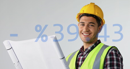 Image of plus, minus, percentile symbols, caucasian engineer wearing helmet looking at blueprint