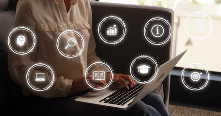 Image of multiple icon in circles over caucasian woman sitting on sofa and using laptop