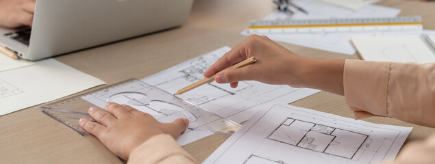 Professional architect drawing blueprint during meeting at modern architectural office on table...