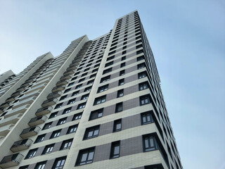 Multi-storey high-rise building with balconies on a blue sky background