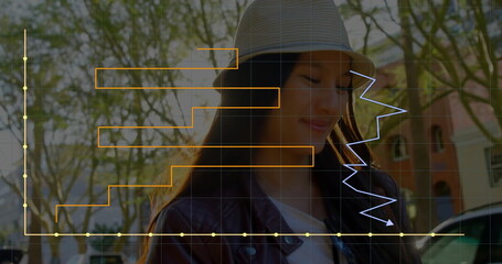 Image of statistic charts on grid over smiling asian woman walking on street