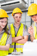 A Group of engineer are examining machine robot arm with smart tablet. Installation indoor industrial factory. Technician coworker check for repair maintenance electronic operation with remote system