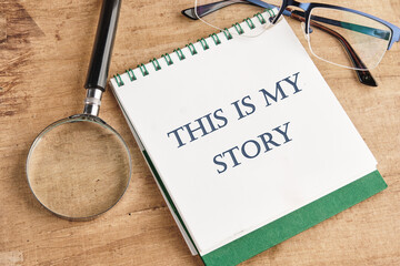 Business and my story concept. Text This is my story on a notebook with a magnifying glass and...