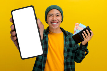 Asian man wearing a beanie hat and casual clothes showing his phone at camera with white blank...