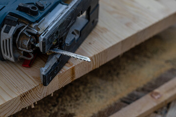 a cut off piece of board with an electric jigsaw on the floor