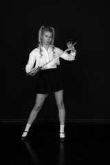 Young blonde woman with vintage katana sword low key black and white portrait