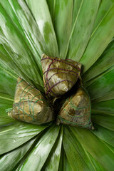 Zongzi. Rice dumpling for Chinese traditional Dragon Boat Festival on green leaf background