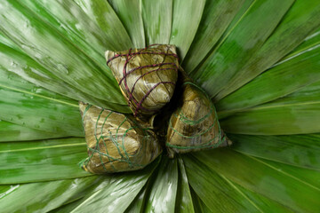 Zongzi. Rice dumpling for Chinese traditional Dragon Boat Festival on green leaf background