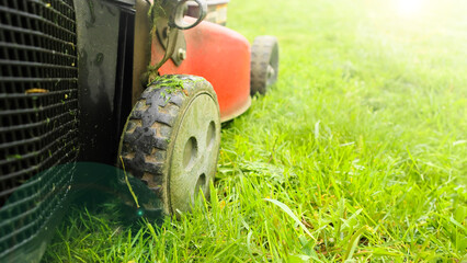 Lawn mower cutting green grass low angle shot with selective focus