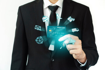 Elegant customer wear black suit and tie hold credit card, cashless technology, by left hand. Smart consumer use hologram graphic interface of e-commerce application platform around hands. Cybercash.