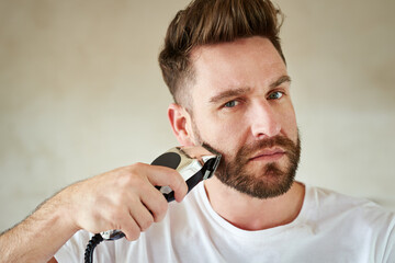 Man, portrait and electric trimmer in bathroom for grooming, skincare or morning routine. Face,...