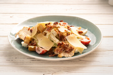 Caesar salad with grilled chicken, lettuce and Parmesan cheese.