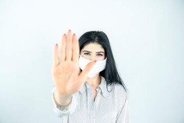 Young woman with surgical mask on face against SARS-CoV-2. woman wearing health mask showing stop...
