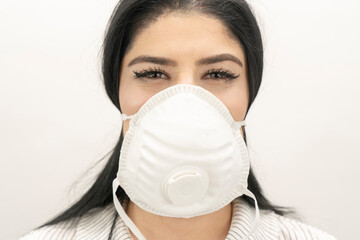 Young woman with surgical mask on face against SARS-CoV-2. COVID-19 Pandemic Coronavirus Young girl...