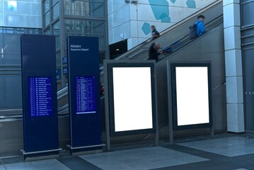 Two vertical white billboards in the station building.