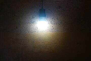 Backdrop of the rammed earth wall with light bulb.