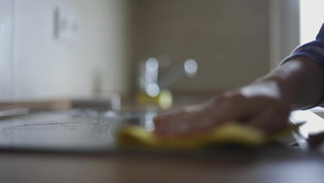 Woman washing a kitchen stove.
