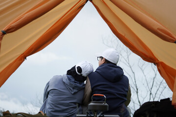 Another couple sat in front of the tent.