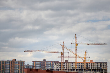 Group of tower crane on construction site. Tall buildings under construction. Real estate construction. Concept of urban development and architecture.