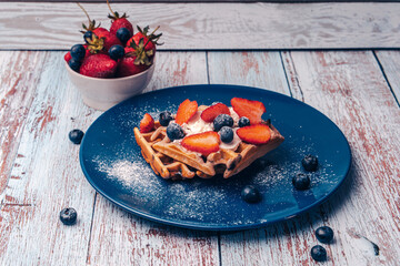 Belgian waffles according to a traditional recipe with strawberries and blueberries and cottage...