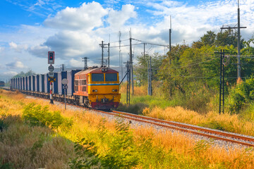 Freight train wagons container locomotive travels along the railway sunny day