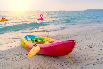 Kayak rowing boat for riding tourists people on a sandy picturesque tropical beach during sunset....