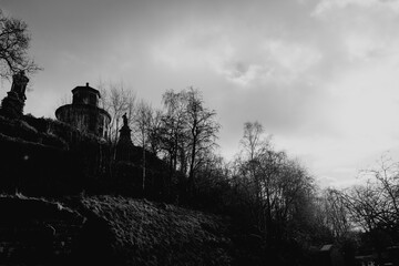 Obraz premium Glasgow Scotland: 12th Feb 2024: Glasgow Necropolis on sunny winter day with spooky bare trees. Black and white white