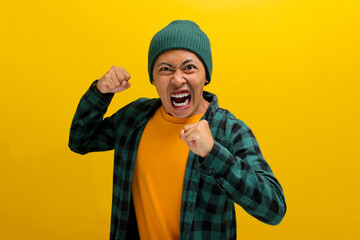 Young Asian man, wearing a beanie hat and casual outfit, is displaying aggression with a defensive...