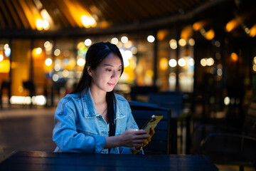 Woman use of mobile phone at outdoor in the evening time