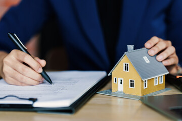 Interest and loan concept, woman is calculating house interest with documents.