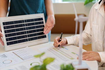 Business eco sustainable electricity, people creating ideas working on Solar panels green energy in...