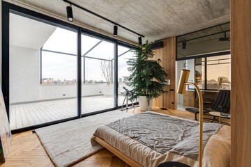 A spacious room with a central bed surrounded by large windows