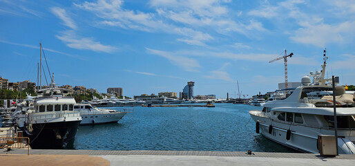 Marina in Barcelona, Spain, with pleasure boats, yachts and motor boats on a blue sea with seafront...
