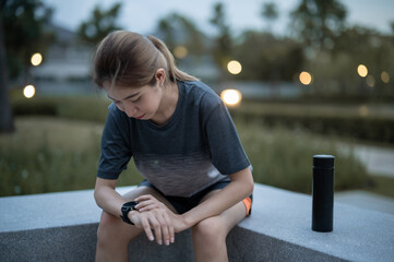 Young woman ,Athlete glancing at her smartwatch.